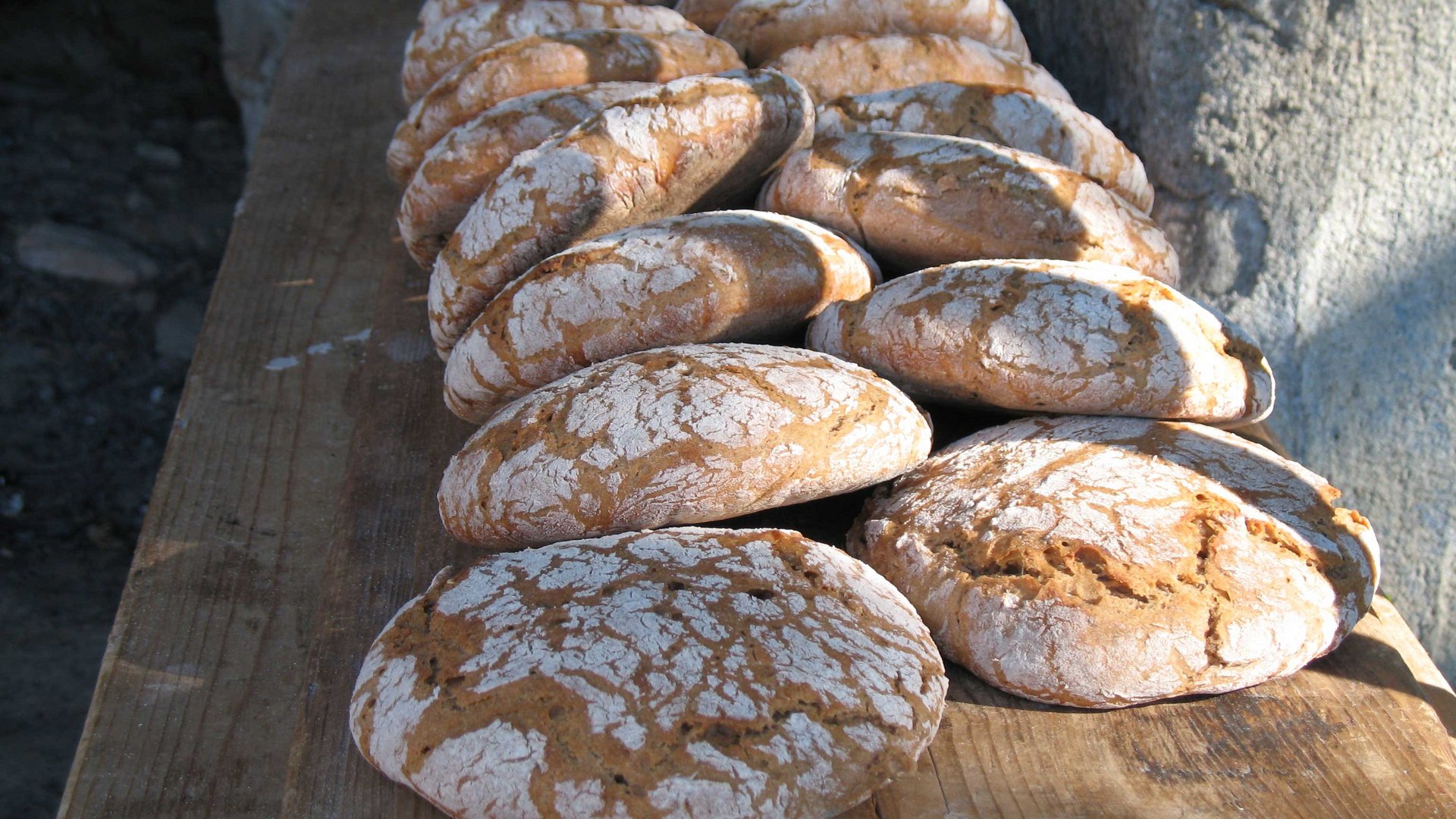 Il Sentiero dei Mulini a Terento Pagnotte di pane rustico appena sfornate su un tavolo di legno