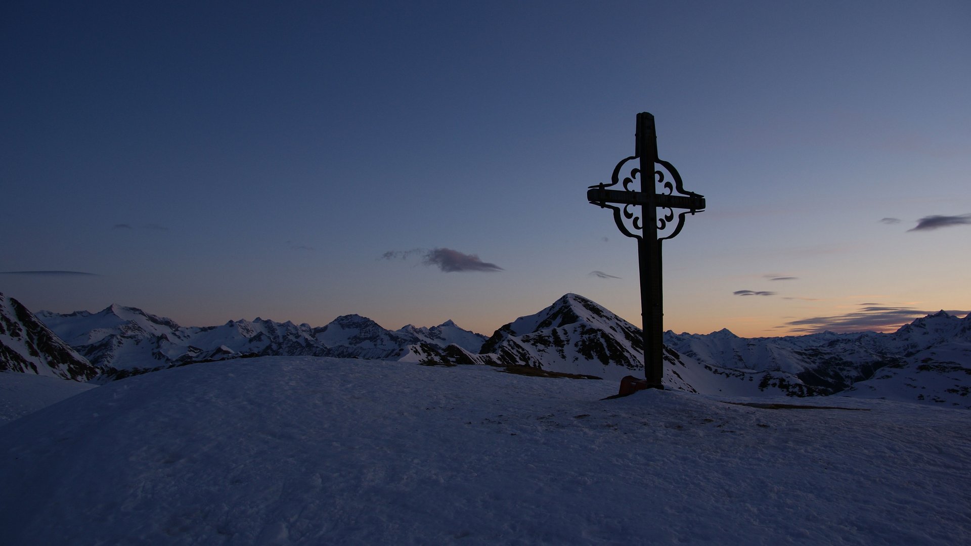 Escursioni a Terento, in Val Pusteria Croce su vetta innevata al tramonto nelle Alpi