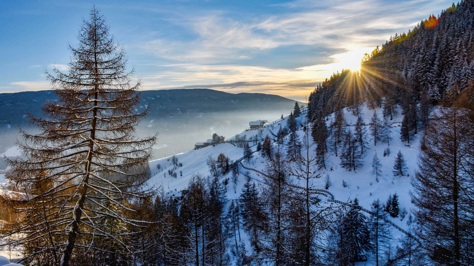 Escursioni a Terento, in Val Pusteria Paesaggio invernale con montagne innevate e raggi di sole