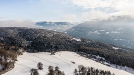 Terento in Val Pusteria Paesaggio invernale con montagne e boschi innevati sotto un cielo azzurro