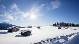 La pista di fondo sull’Alpe di Rodengo e Luson Baite di legno innevate su montagna soleggiata con cielo azzurro