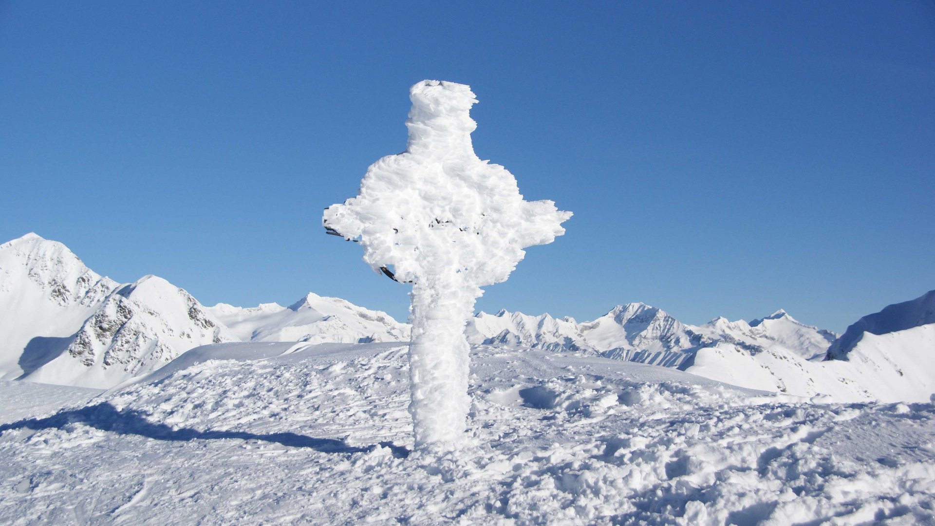 Escursioni a Terento, in Val Pusteria Croce coperta di neve sulla cima di una montagna innevata