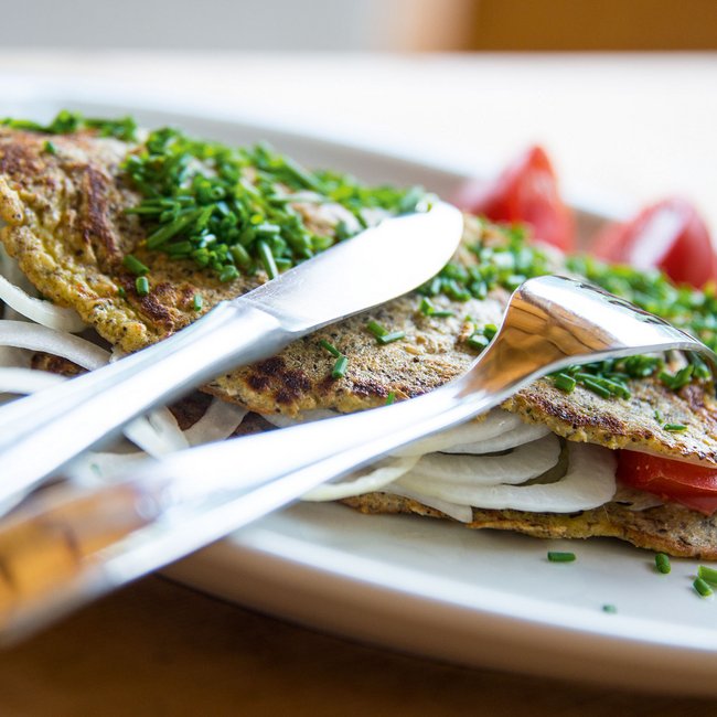 Hofschank Wieserhof Una frittata ripiena di cipolle e pomodori, cosparsa di anelli di erba cipollina fresca.