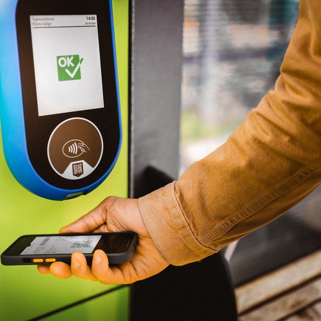 Almencard: la carta che apre tutte le porte Persona che scansiona il codice del biglietto digitale con lo smartphone