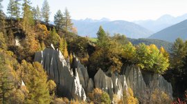 Le piramidi di terra di Terento Piramidi di terra circondate da alberi autunnali e montagne