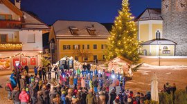 L’Avvento di Terento Albero di Natale illuminato con persone che partecipano a una festa in piazza
