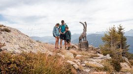 Outdoor Escape sul Monte Gitschberg Famiglia con mappa vicino a scultura di capra in montagna