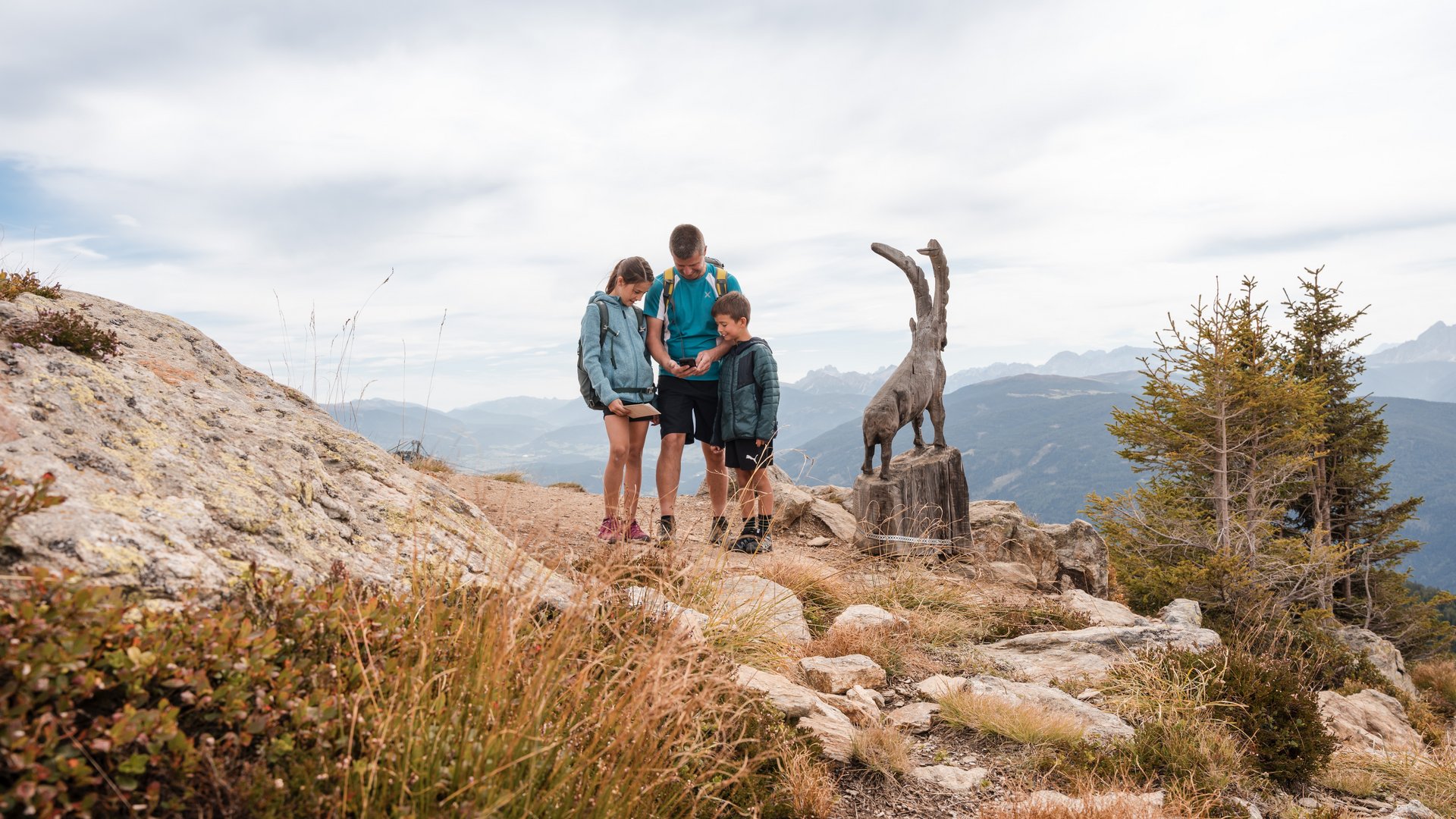 Outdoor Escape sul Monte Gitschberg Famiglia con mappa vicino a scultura di capra in montagna