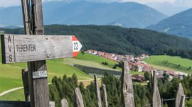 Terento in Val Pusteria Cartello escursionistico Terenten con vista su campi verdi e montagne