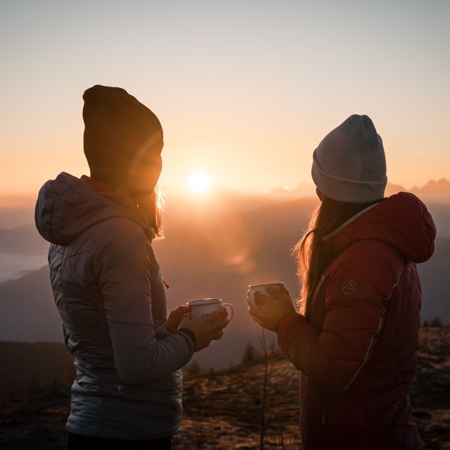 Almencard: la carta che apre tutte le porte Due donne che bevono tè caldo al sorgere del sole in montagna