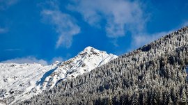Escursioni a Terento, in Val Pusteria Montagne innevate con foresta di conifere sotto cielo azzurro