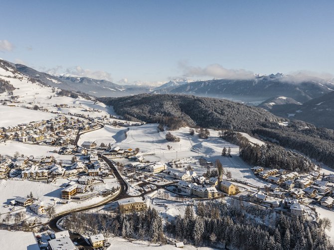 Le località dell’area vacanze Rio Pusteria Paesaggio invernale con villaggio innevato in una valle e montagne sullo sfondo