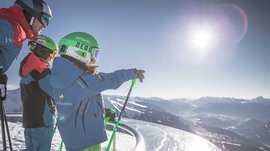 La piattaforma panoramica Gitschberga a Maranza (BZ) Tre sciatori con casco guardano le montagne innevate sotto il sole