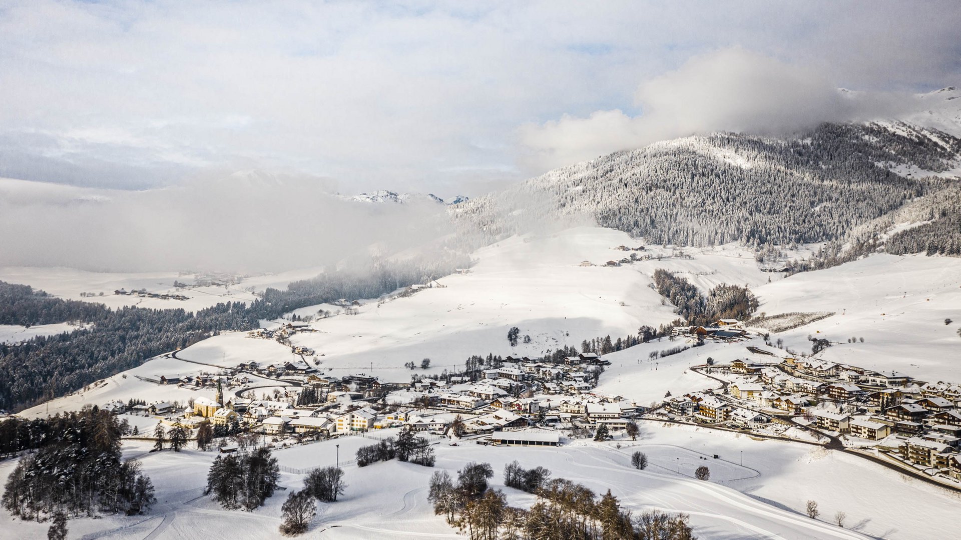Terento in Val Pusteria Villaggio innevato nelle Alpi con montagne e nuvole sullo sfondo
