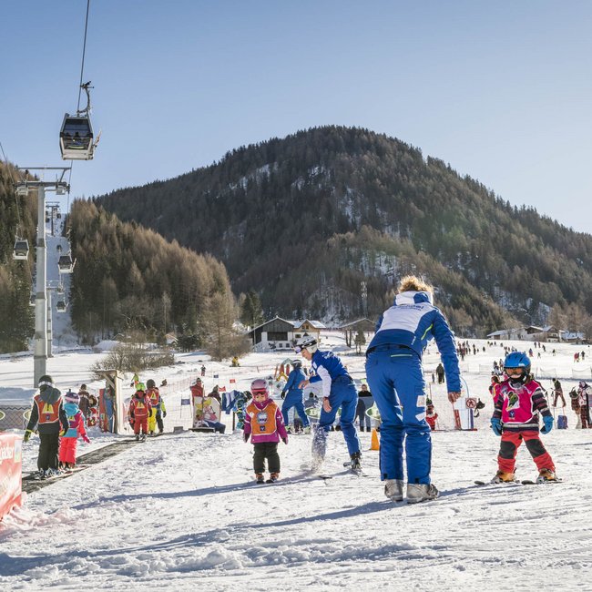 Cercate un hotel vicino a Bressanone? Bambini imparano a sciare su una pista per principianti con istruttori
