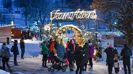 L’Avvento di Terento Persone che visitano un mercato natalizio di Avvento sotto la neve di sera