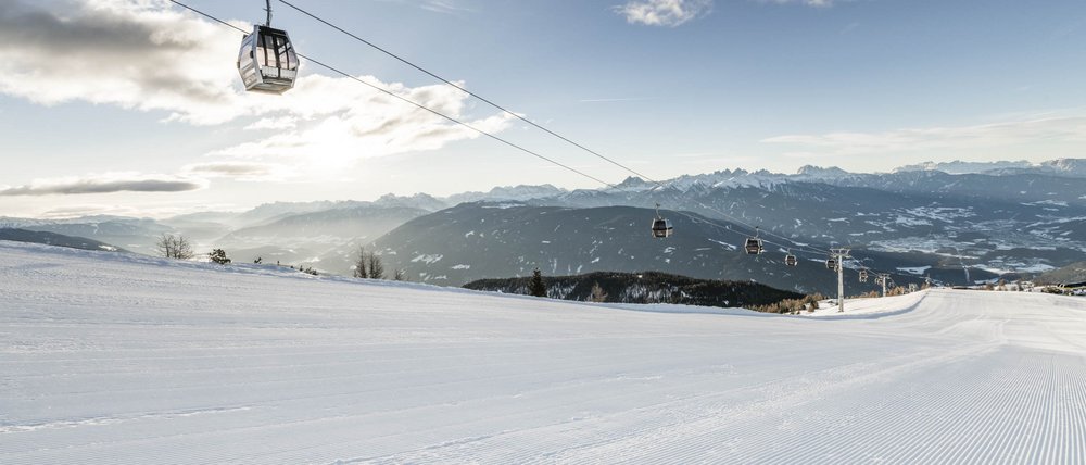 Le località dell’area vacanze Rio Pusteria Pista da sci vuota con cabinovia e montagne sullo sfondo