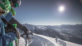 La piattaforma panoramica Gitschberga a Maranza (BZ) Sciatori leggono una piastra informativa con sole e panorama montano