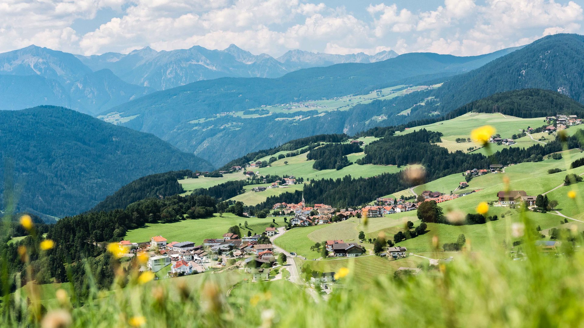 Terento in Val Pusteria Vista di un villaggio in una verde valle collinare con montagne sullo sfondo