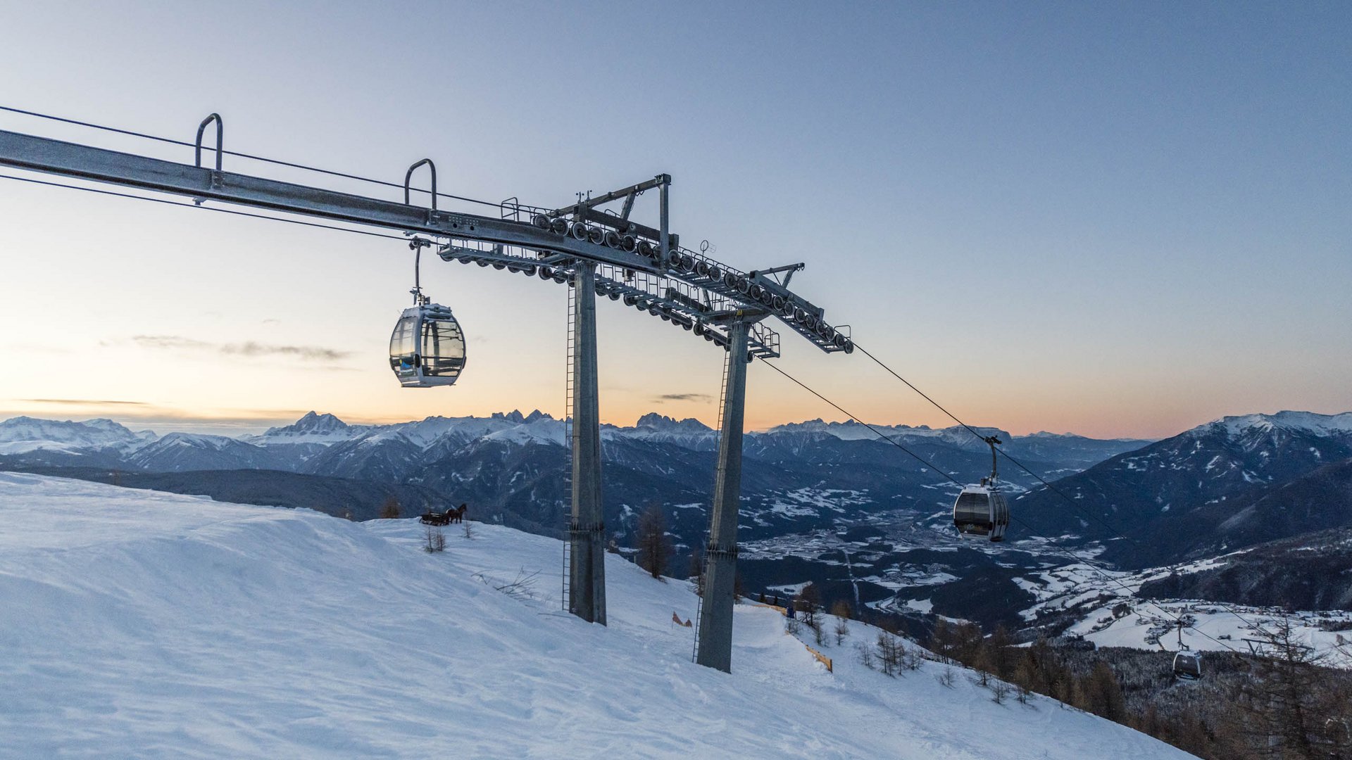 Speciale avvento 50% Funivia al tramonto sopra montagne innevate