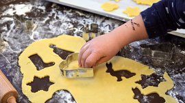 L’Avvento di Terento Bambino che usa formine per biscotti su pasta stesa infarinata