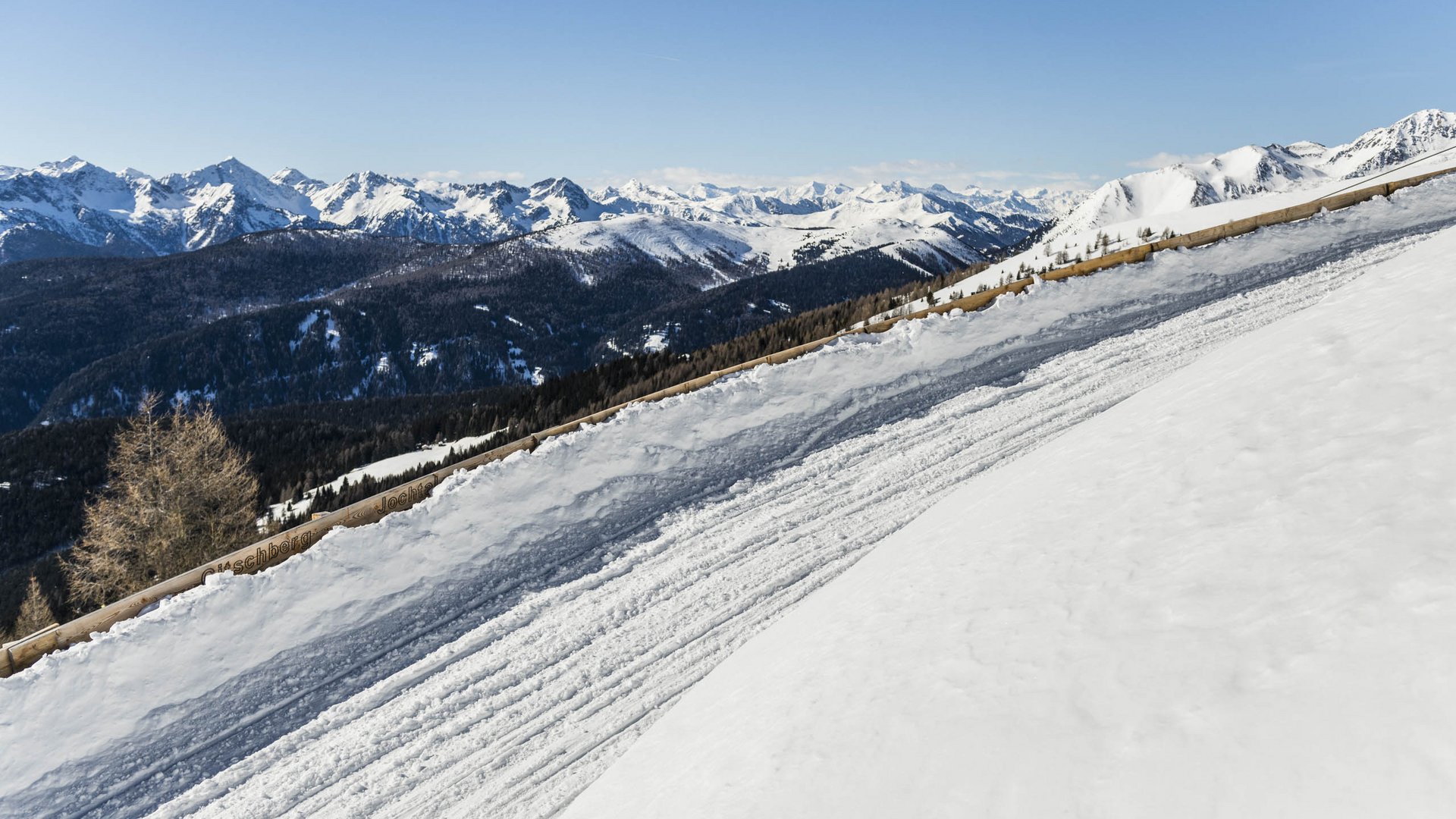 Dove slittare in Alto Adige – Rio Pusteria Pista da sci innevata con panorama montano e cielo limpido