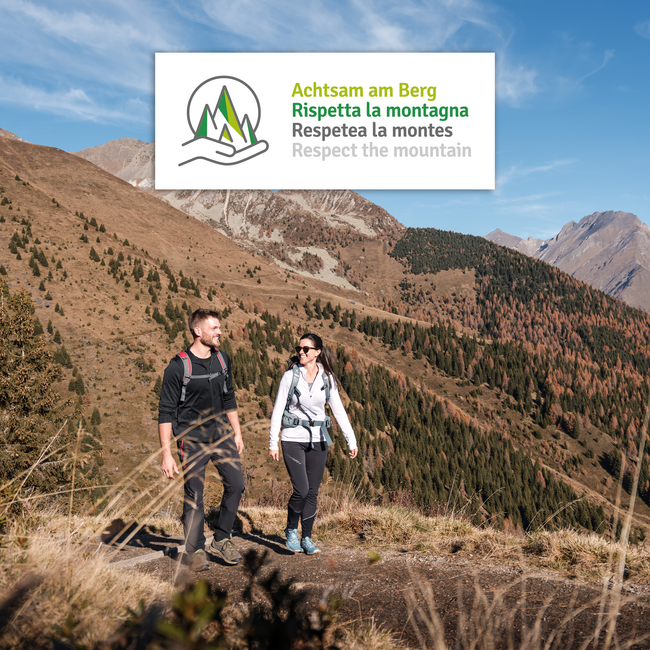 Vacanze sostenibili in Alto Adige Escursionisti su sentiero di montagna con cartello Rispetta la montagna